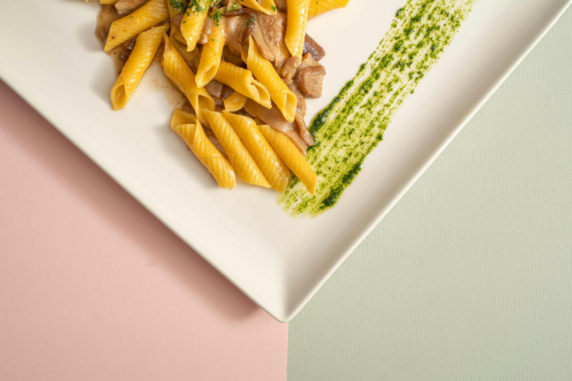 Frische Pasta mit Pesto und Pilzen auf elegantem Teller